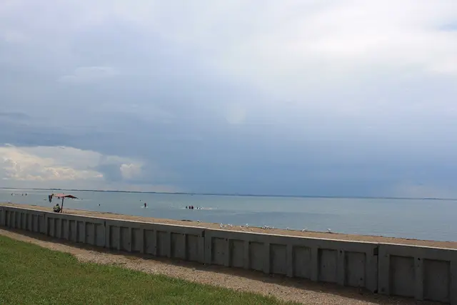 Beach and seawall under stormy sky